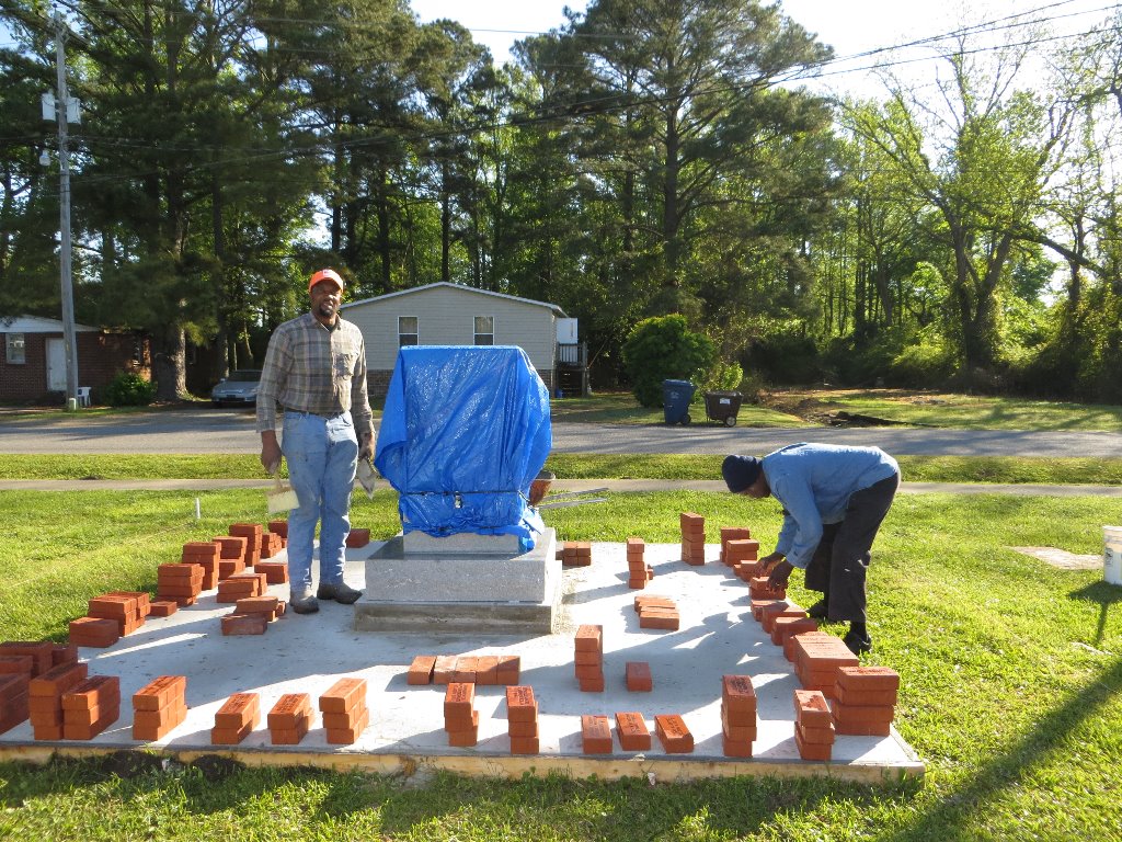 Arranging bricks for placement around monument